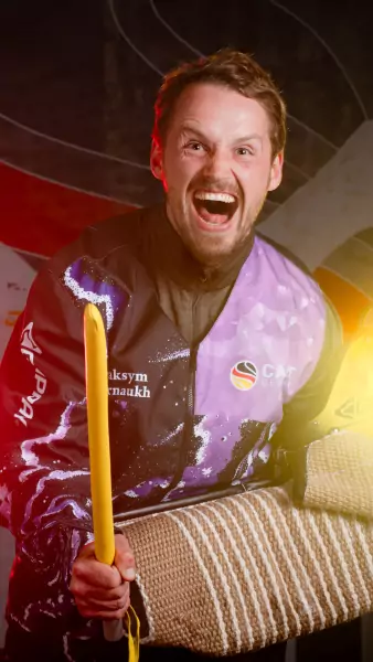 maksym karnaukh 1 Maksym Karnaukh lacht ausgelassen in die Kamera und hält einen gelben Stock sowie den Gappay-Ärmelschutz; er trägt die schwarz-lila CACIT-Germany-Schutzdienstausrüstung vor dem CACIT-Germany-Backdrop.