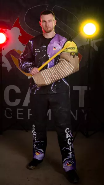soeren waerum Sören Waerum steht in voller schwarz-lila CACIT-Germany-Schutzdienstausrüstung mit Gappay-Ärmelschutz und gelbem Stock vor dem offiziellen CACIT-Germany-Backdrop.